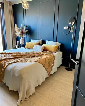 modern slaapkamer interieur met donkerblauwe muur en gele kussens