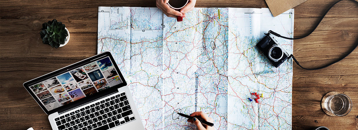 landkaart op de tafel en reis inspiratie op de laptop