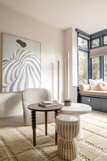 Japandi woonkamer met beige fauteuil, houten tafel, vensterbank en abstract portret