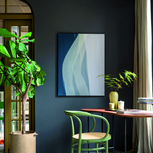 Interieur met donkergrijze muur, abstract schilderij, groene stoel, houten tafel en grote kamerplant