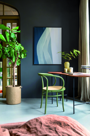 Interieur met donkergrijze muur, abstract schilderij, groene stoel, houten tafel en grote kamerplant