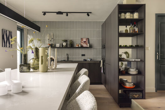 Moderne keuken met donker hout, open rekken en kunst aan de wand