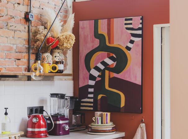 Abstract schilderij met zwart-witte lijnen in kleurrijke keuken met rode muur en keukenspullen