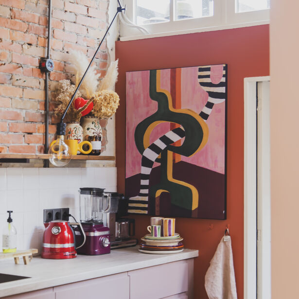 Abstract schilderij met zwart-witte lijnen in kleurrijke keuken met rode muur en keukenspullen