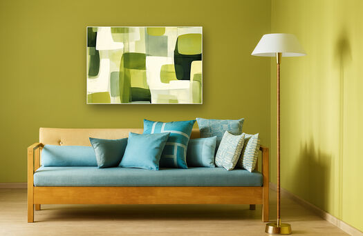 Houten bank met blauwe kussens tegen gele muur met geometrisch groen schilderij