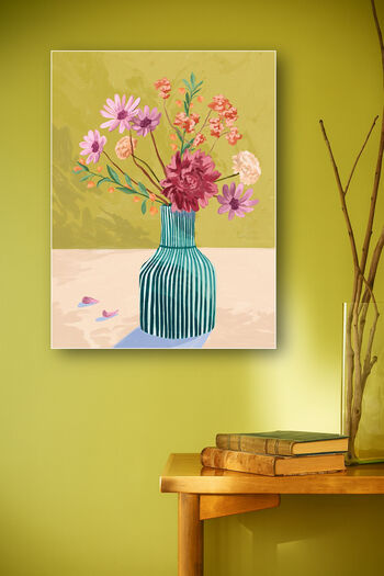 Schilderij van bloemenvaas met roze bloemen tegen gele muur boven houten console