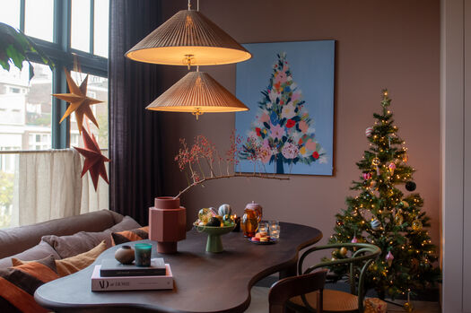 Gezellige woonkamer met kerstboom, bloemen schilderij en bruine hanglamp