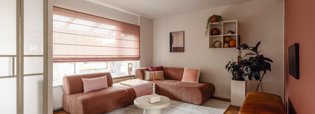 Roze woonkamer met hoekbank, wandkast en abstracte wandkunst