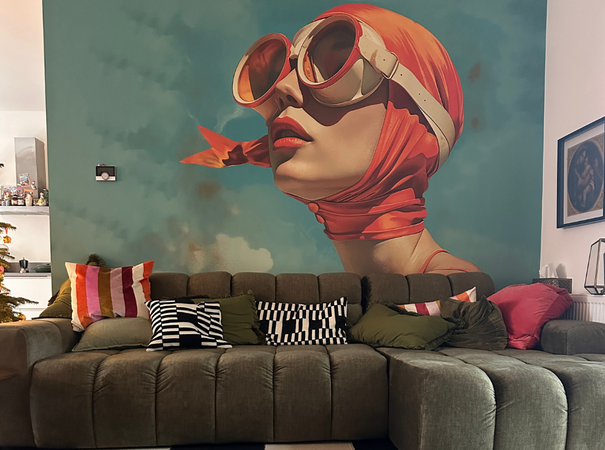 Woonkamer met grote behangprint van vrouw met rode hoofddoek en zonnebril