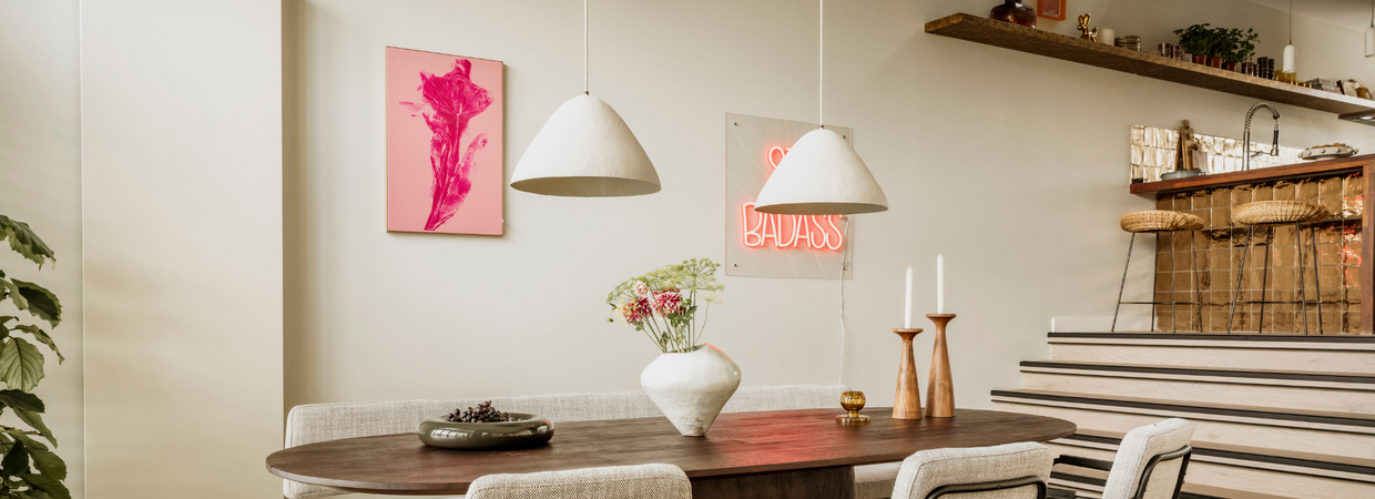Lichte eetkamer met roze kunstwerk en neon art