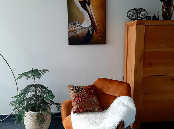 oranje en bruin kunstwerk van vogel aan de muur