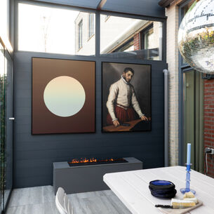 Overdekte patio met donkergrijze muur, abstract en klassiek kunstwerk boven haard