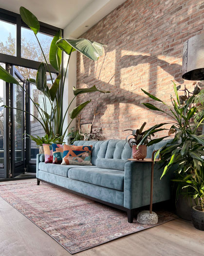 zithoek interieur met planten en blauwe bank